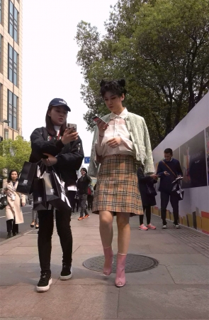 粉色短靴短裙卷发女子