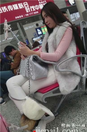 4k-候车室内拍摄紧身白裤甜美妹子忙直播。