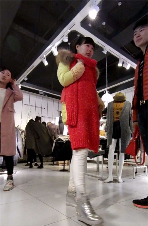 商场挑衣服的紧身白裤美女