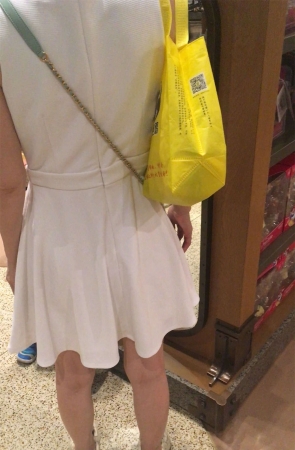 白色连衣裙少妇给女儿买洋娃娃