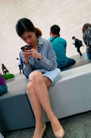 玩手机的蓝色短裙肉色丝袜高跟白腿OL妹子