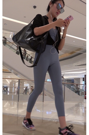 商场里戴着墨镜的紧身裤美女