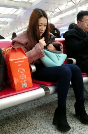 高铁站拍摄蓝色紧身牛仔裤漂亮长发美女