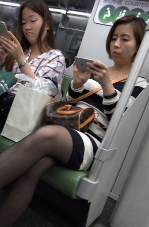 地铁上玩手机的黑丝美女