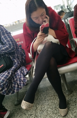 高铁站候车大厅等车的黑色丝袜美腿少妇