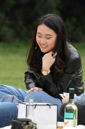 跟朋友草地上打牌的甜美女孩