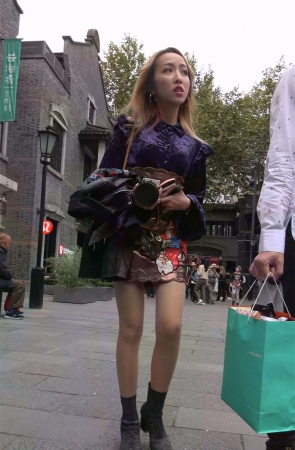 手持单反的时尚美裙美腿姑娘