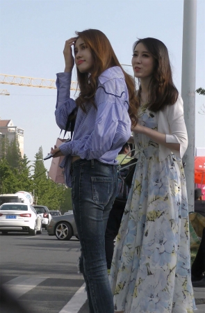 路边等车的牛仔裤衬衫美女