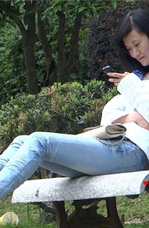 紧身蓝牛美眉石凳上玩手机晾脚