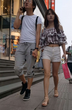 白色紧绷热裤长发美女和男友一起逛街